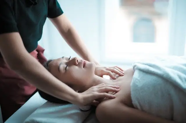 Therapist massaging a client’s neck and shoulders.