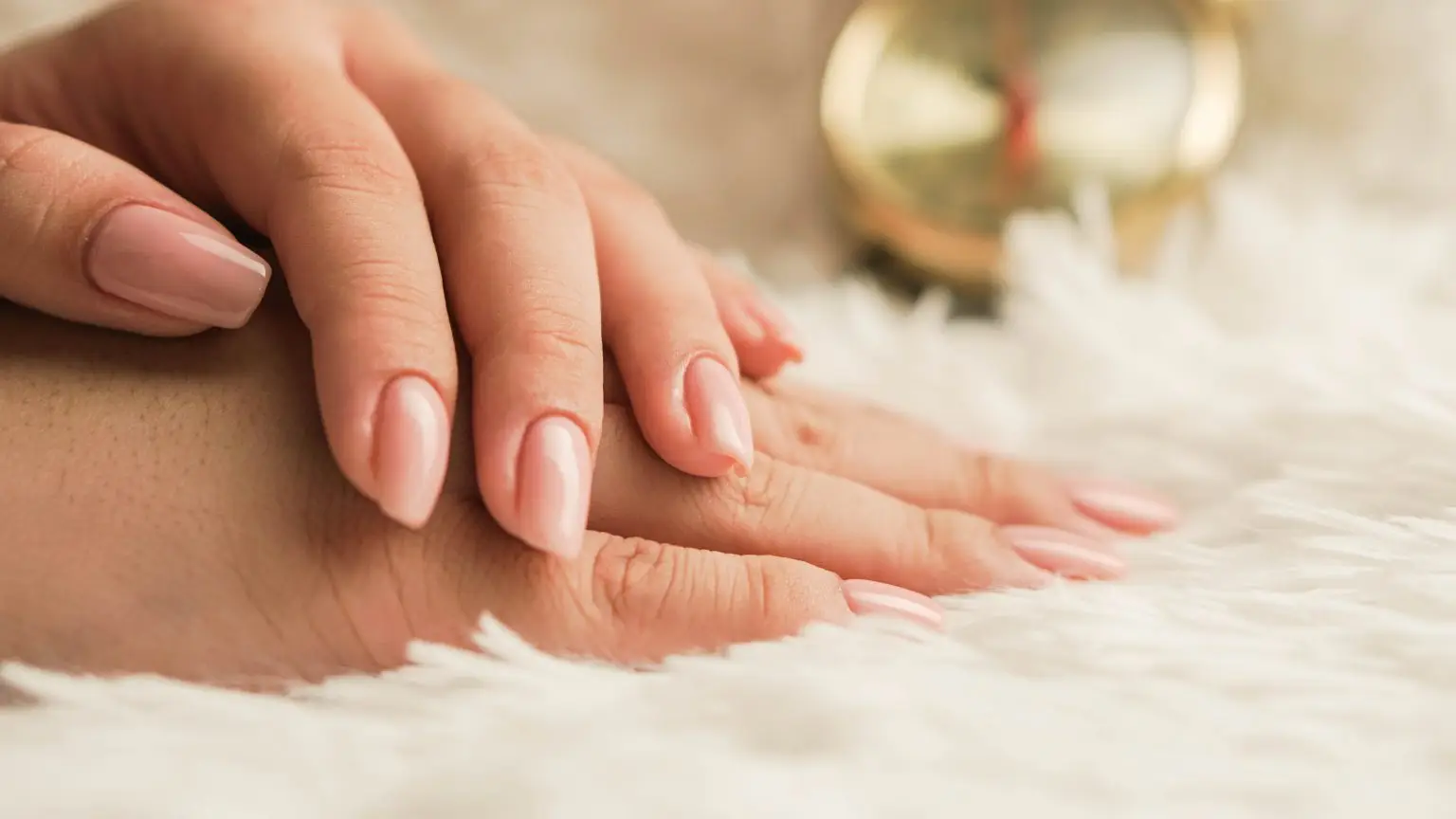 Therapist massaging a client’s hand on a towel.